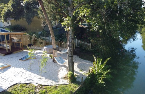 Weeki Wachee Gardens House | River Beach Retreat: with Tiki Bar, Fire Pit, Hot Tub & Clear Kayak